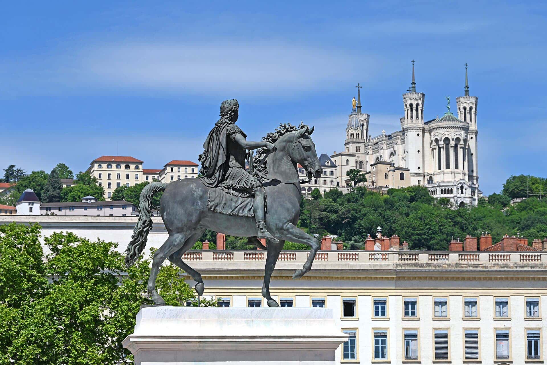 La statue de Louis XIV place Bellecour, et la basilique de Fourvière sur sa colline