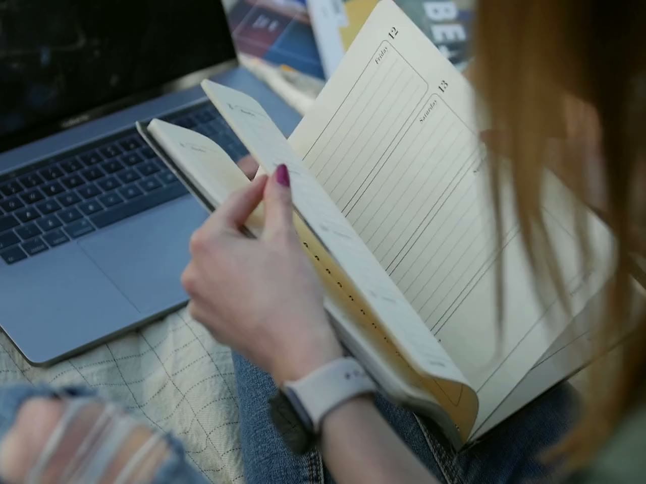 Une propriétaire feuillette son agenda à côté de son ordinateur